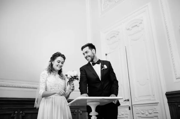 美丽的新娘和新郎在注册时 黑色和白色的照片 — 图库照片