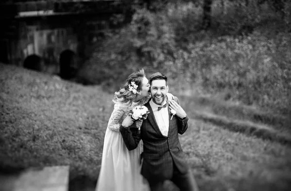 彼らの結婚式の日に抱きしめて 夏の公園で微笑んでスタイリッシュな花嫁と新郎 黒と白の写真 — ストック写真