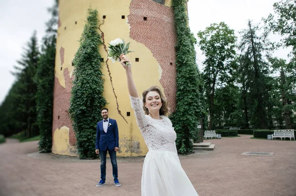 노란색 아이비의 배경에 공원에서 자신의 결혼식 신랑에 꽃다발을 던지는 — 스톡 사진