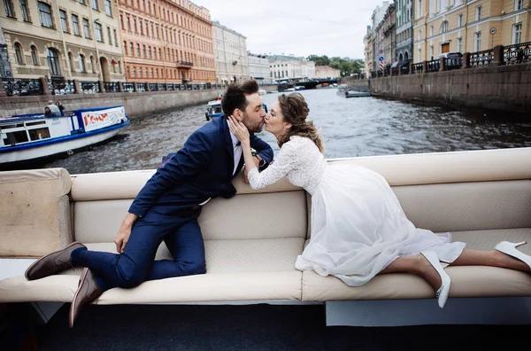 时尚的新娘和新郎在他们的婚礼当天 有乐趣和接吻在河上的船旅行 — 图库照片