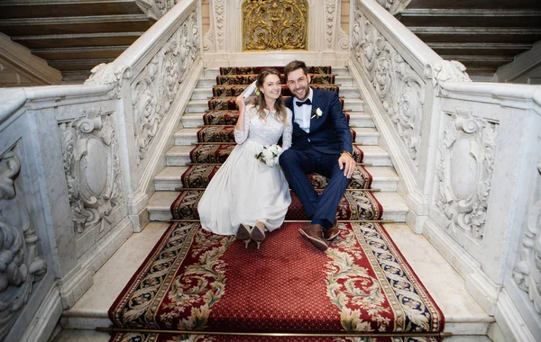 宮殿での登録後 階段の上に座って幸せな新郎新婦 — ストック写真