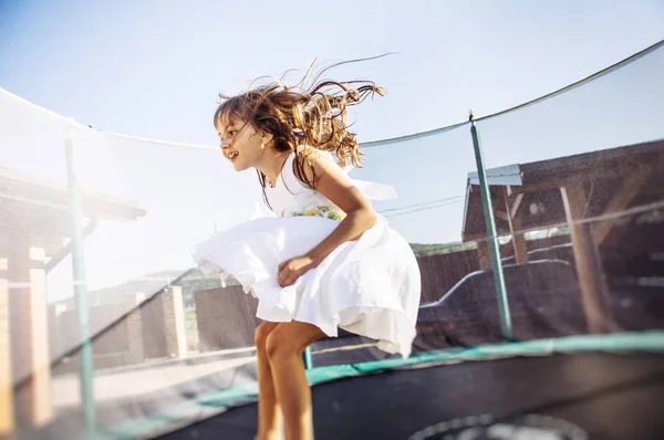 Menina Bonito Vestido Branco Divertindo Trampolim — Fotografia de Stock