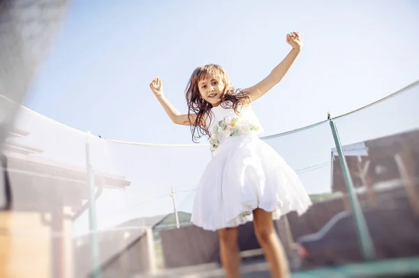 Menina Bonito Vestido Branco Divertindo Trampolim — Fotografia de Stock