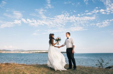 Mutlu genç gelin ve damat deniz veya nehir yakınında bir yürüyüş