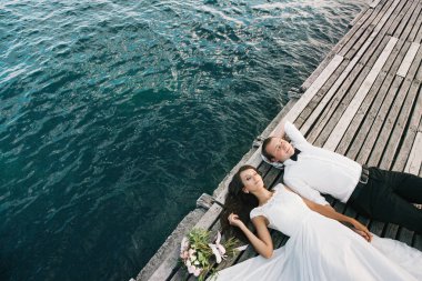 Mutlu genç gelin ve damat deniz veya nehir yakınında bir yürüyüş