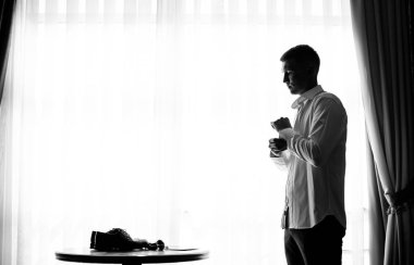 Genç ve şık damat düğün gününde sabahları giyer.