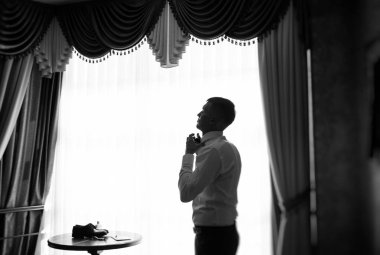 Genç ve şık damat düğün gününde sabahları giyer.