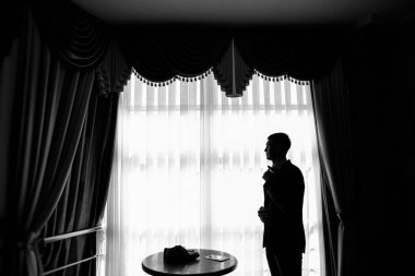 Genç ve şık damat düğün gününde sabahları giyer.