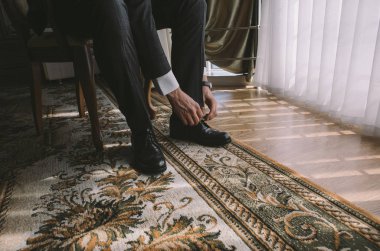 Genç ve şık damat düğün gününde sabahları giyer.