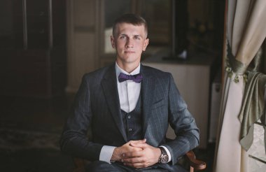 sabah şık damat - bir vintage odada poz gri bir ceket genç bir adam sarışın