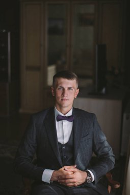 sabah şık damat - bir vintage odada poz gri bir ceket genç bir adam sarışın