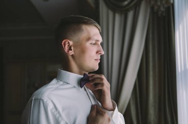 Genç ve şık damat düğün gününde sabahları giyer.