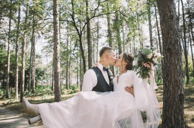 aşık şık ve ihale çift - gelin ve damat - ormanda bir yürüyüş onların düğün günü, gülerek ve sarılma