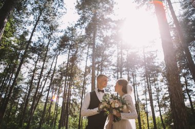 aşık şık ve ihale çift - gelin ve damat - ormanda bir yürüyüş onların düğün günü, gülerek ve sarılma