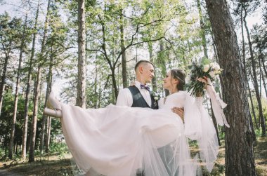 aşık şık ve ihale çift - gelin ve damat - ormanda bir yürüyüş onların düğün günü, gülerek ve sarılma