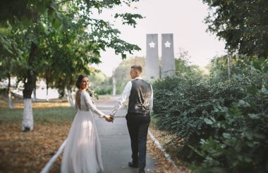 aşık şık ve ihale çift - gelin ve damat - ormanda bir yürüyüş onların düğün günü, gülerek ve sarılma