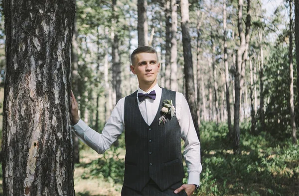 时尚的年轻新郎在森林的婚礼上摆姿势 — 图库照片