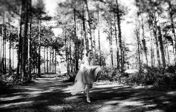 柔らかい若い花嫁は結婚式の日に森の中で幸せに実行されます — ストック写真