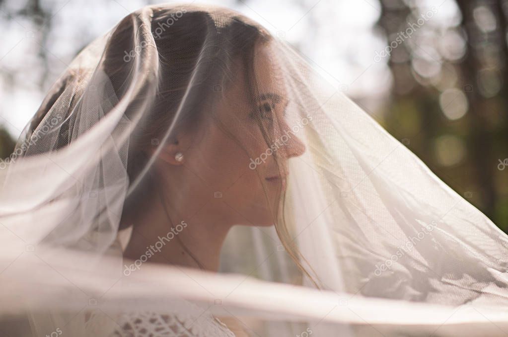 tender young happy bride in the forest wedding day in the sun and in veil
