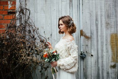 Çiçeklerle poz veren genç mutlu gelin