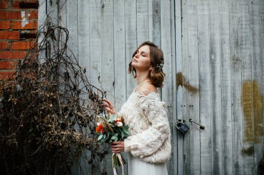 Çiçeklerle poz veren genç mutlu gelin