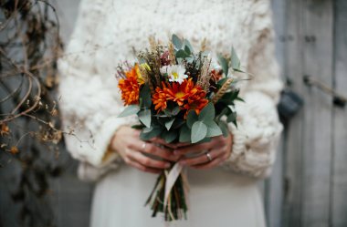 Genç gelin elinde bir demet çiçek tutuyor