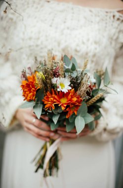 Genç gelin elinde bir demet çiçek tutuyor