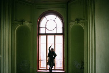 St. Petersburg 'da yeşil bir verandada yeşil elbiseli güzel sarışın kız poz veriyor.