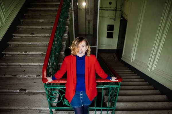 Colorful Blonde Girl Red Jacket Blue Jacket Sits Floor Entrance — Stock Photo, Image