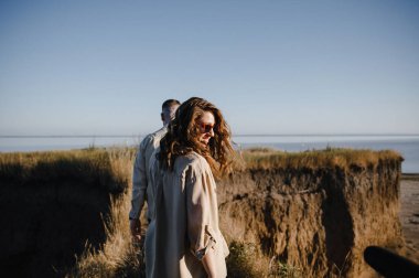 Nişandan sonra gölün yanındaki dağlarda yürüyüş yapan kahverengi tişörtlü şık bir çift. Mutlu erkek ve kız kucaklaşması. Sevgililer Günü için gerçek bir hikaye.