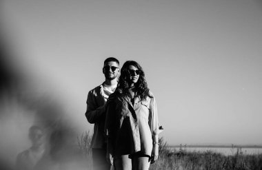 Nişandan sonra gölün yanındaki dağlarda yürüyüş yapan kahverengi tişörtlü şık bir çift. Mutlu erkek ve kız kucaklaşması. Sevgililer Günü için gerçek bir hikaye.