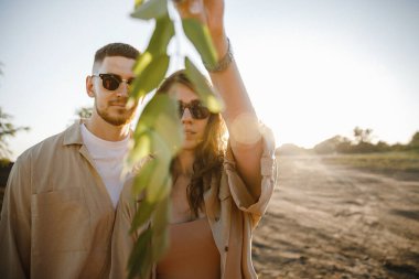 Nişandan sonra gölün yanındaki dağlarda yürüyüş yapan kahverengi tişörtlü şık bir çift. Mutlu erkek ve kız kucaklaşması. Sevgililer Günü için gerçek bir hikaye.