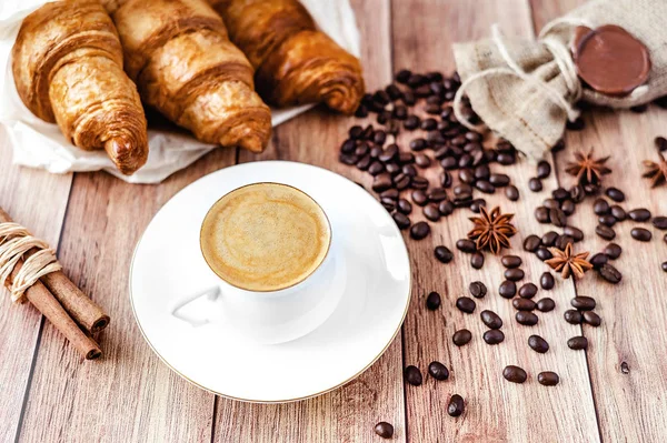 Perfect breakfast of croissants and coffee on wooden table. Rustic style.