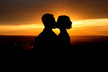 Genç çift günbatımı arka planda, öpüşme siluet