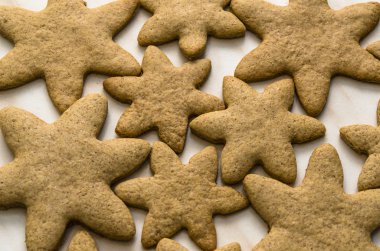 Gingerbread ev pişmiş bir sac pişirme ve pişirme kağıdı - Noel kavramı ile ev-pişmiş çerezleri mutfak ile mutfak yüzeyinde.
