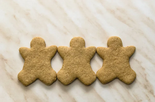 Home-baked gingerbread on a kitchen surface with a baking sheet and baking paper - Christmas concept with home-baked cookies in the kitchen.