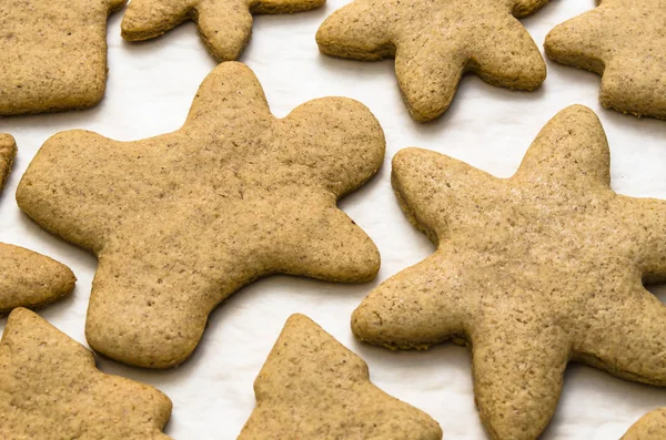 Home-baked gingerbread on a kitchen surface with a baking sheet and baking paper - Christmas concept with home-baked cookies in the kitchen.