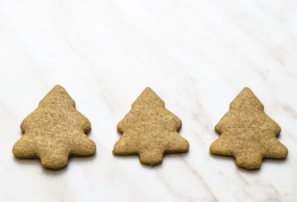 Home-baked gingerbread on a kitchen surface with a baking sheet and baking paper - Christmas concept with home-baked cookies in the kitchen.