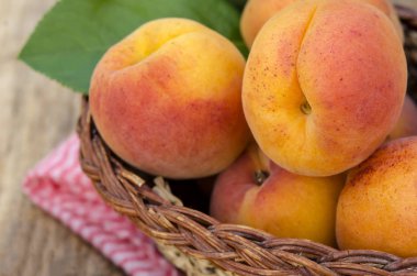 Rustik arka plan üzerinde bir sepet içinde lezzetli olgun kayısı. Sağlıklı gıdalar. Yakın çekim