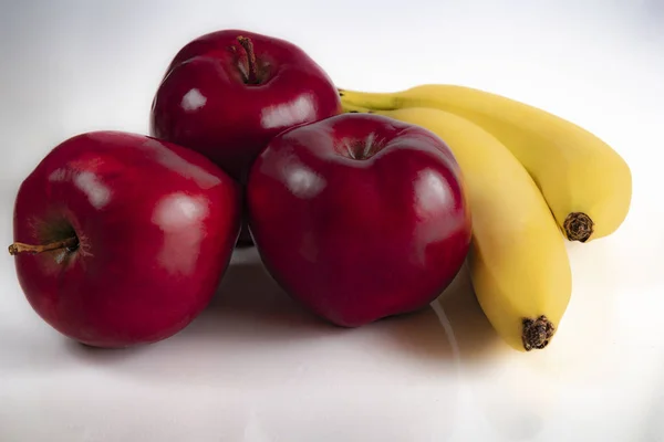 Rote Äpfel mit reifen Bananen auf weißem Hintergrund — Stockfoto