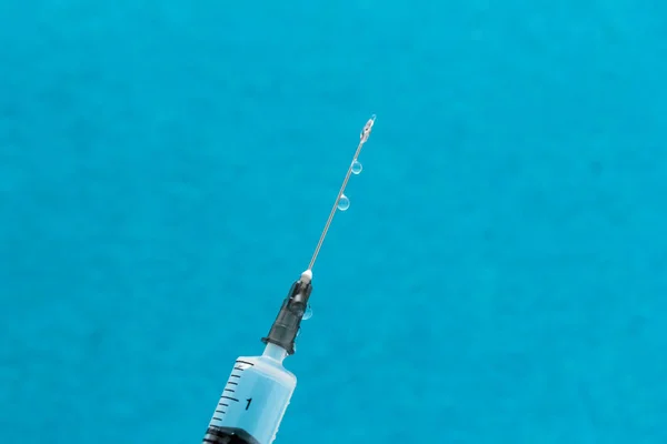 Siringa medica con medicinale su sfondo blu — Foto Stock