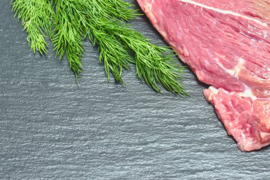 Dereotu bir delikanlı ile siyah bir arka planda ham taze sığır eti