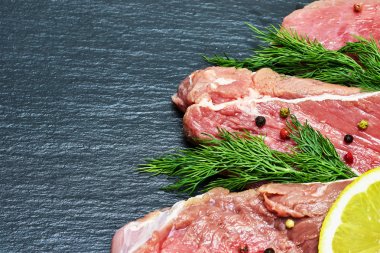 Siyah bir arka planda dereotu ve limon bir delikanlı ile ham taze sığır eti