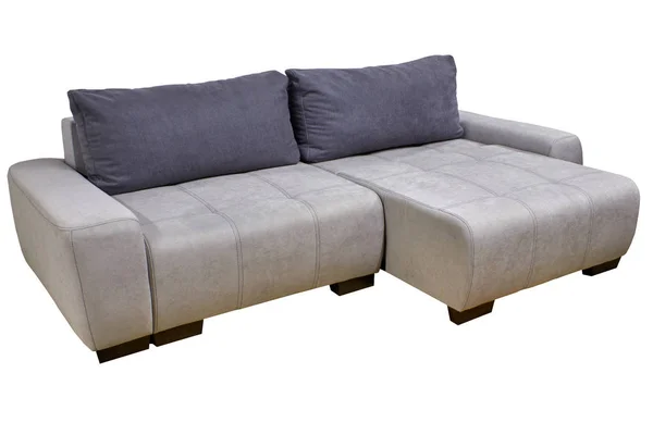 Современный стильный угловой диван из белой ткани с серыми подушками — стоковое фото
