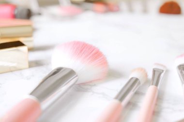 Kozmetik kompozisyon. Pembe fırça seti, ruj, allık tarih ve göz farı paleti mermer masada. Kozmetik kadınlar için masasına kavramı. Kozmetik ürünleri. Düz yatıyordu, en iyi görünüm. Kopya alanı.