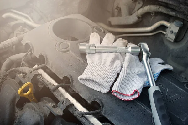 Selective focus on duty dirty glove with car engine with tools