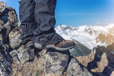 Tepeye kadar karlı dağlar arka girişi önünde buzlu yürüyüş ayakkabıları bir adam duruyor. Ayak kapatın. Kavramı seyahat yol ve hedeflere ulaşmada