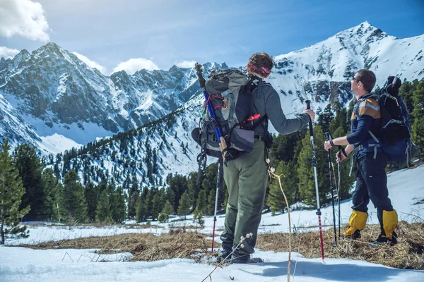 トレッキング ポールがハイカーは 晴れた日の峰の麓で雪に覆われた山に立ちます 概念は旅行し 目標を達成します — ストック写真