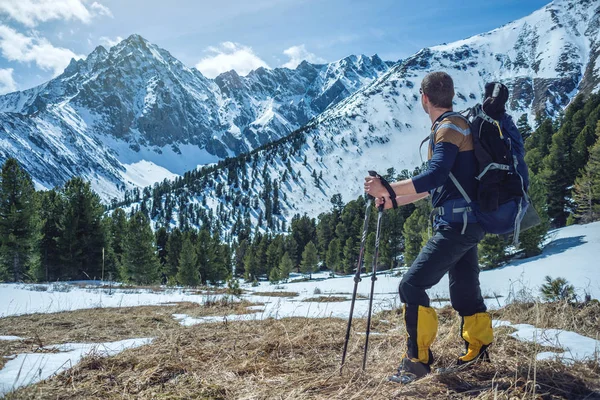 晴れた日の峰の麓で雪の山にトレッキング ポールが男性ハイカーが立っています 概念は旅行し 目標を達成します — ストック写真