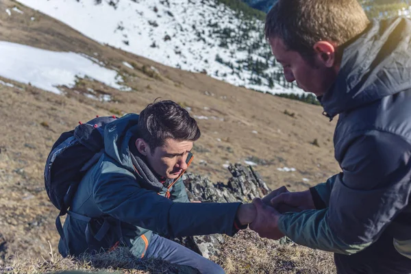 Een Man Helpt Zijn Vriend Klimmen Naar Top Wandelaar Geeft — Stockfoto